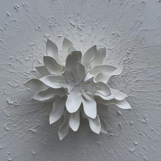 Puritate – arta contemporana tridimensionala, floare alba pe fundal texturat.